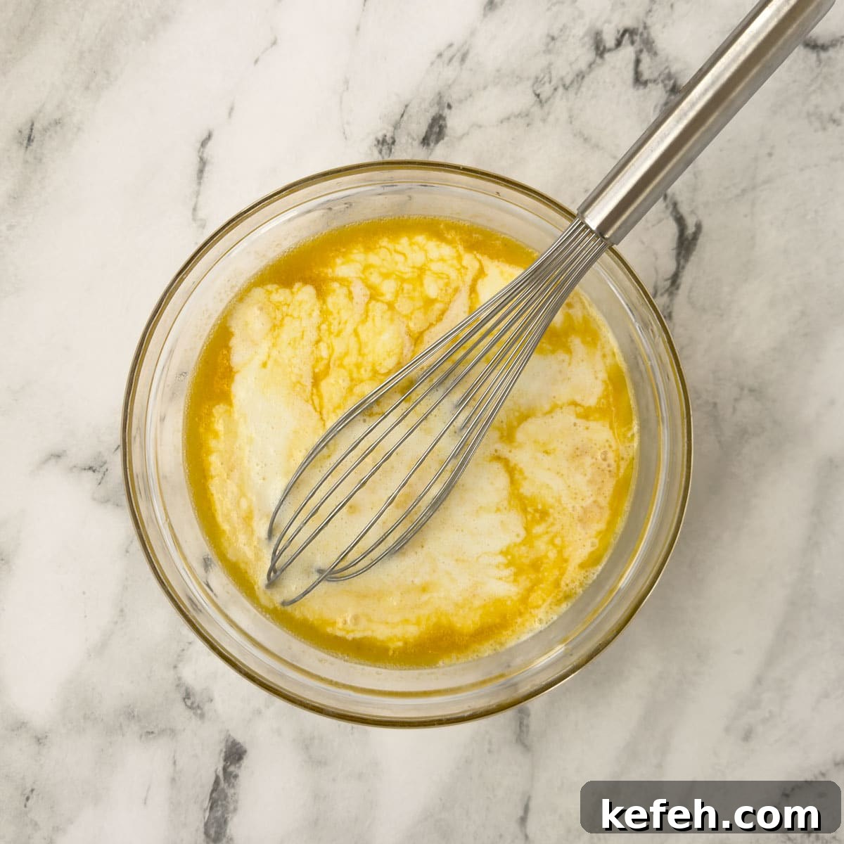 Pancake batter being mixed with a whisk.