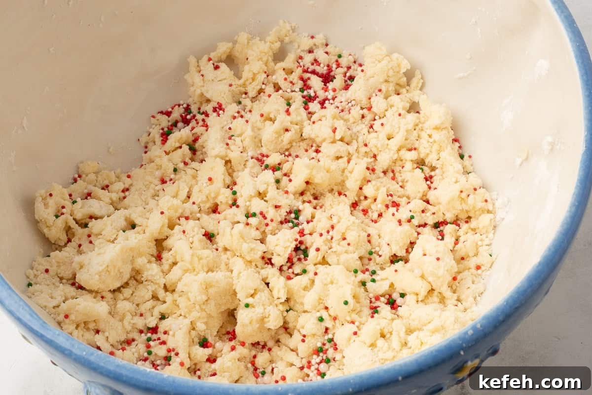 Sprinkles are added to cookie dough batter in blue mixing bowl.