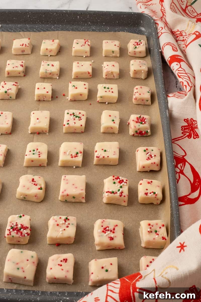 Unbaked shortbread bites on a parchment lined baking sheet, ready to go into the oven.