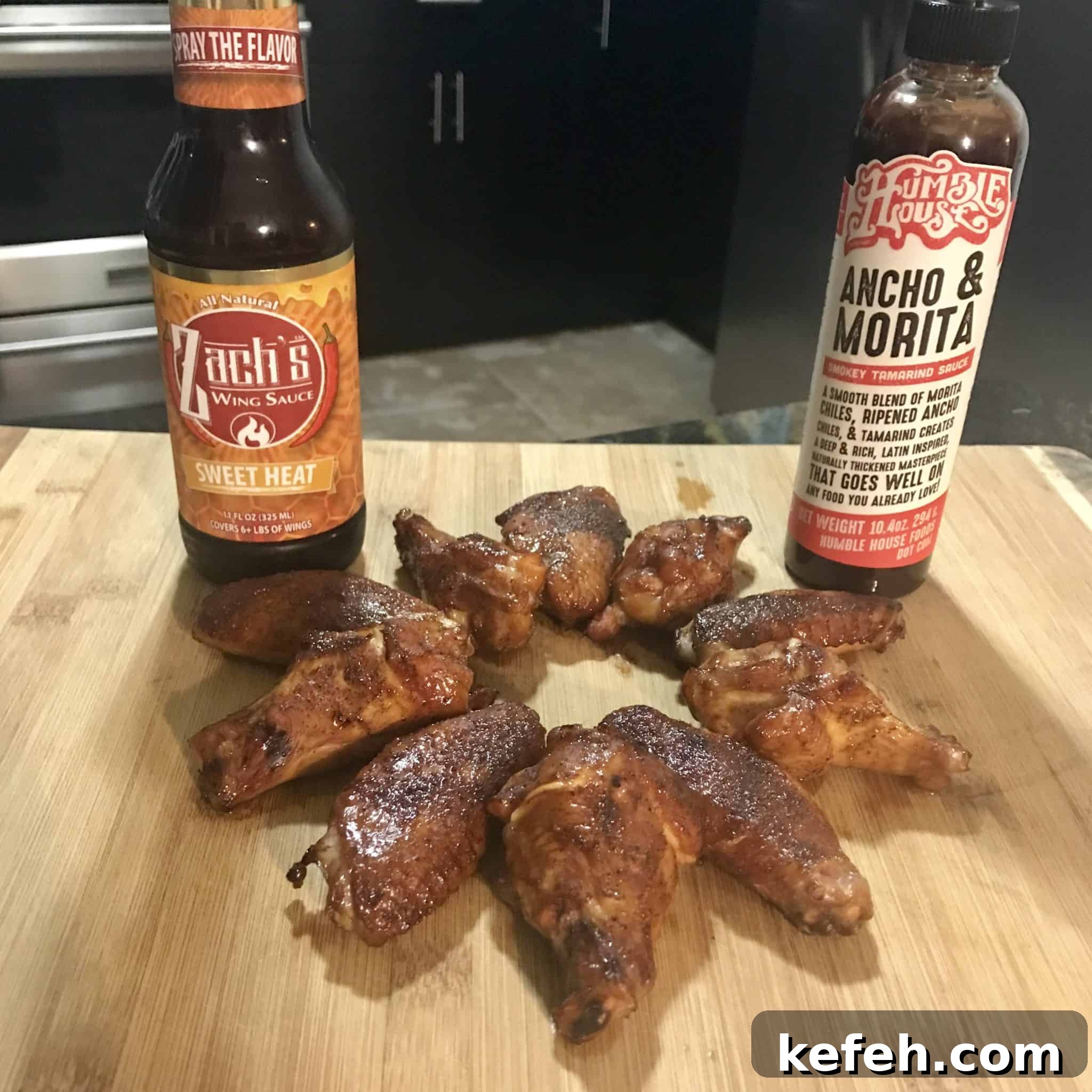 Smoked chicken wings on wooden cutting board with two sauces 