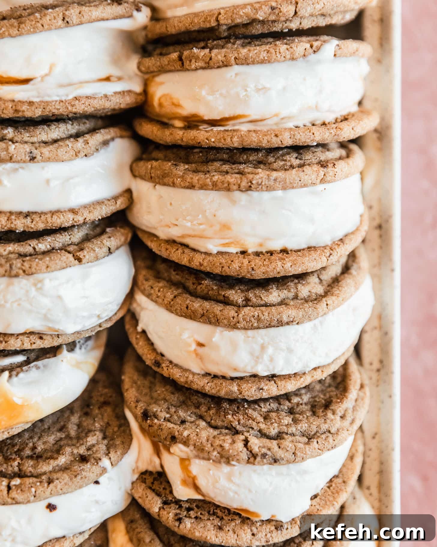 Salted Caramel Coffee Ice Cream Sandwiches Recipe 3 An overhead closeup of cookie ice creams on a white tray with a pink background.