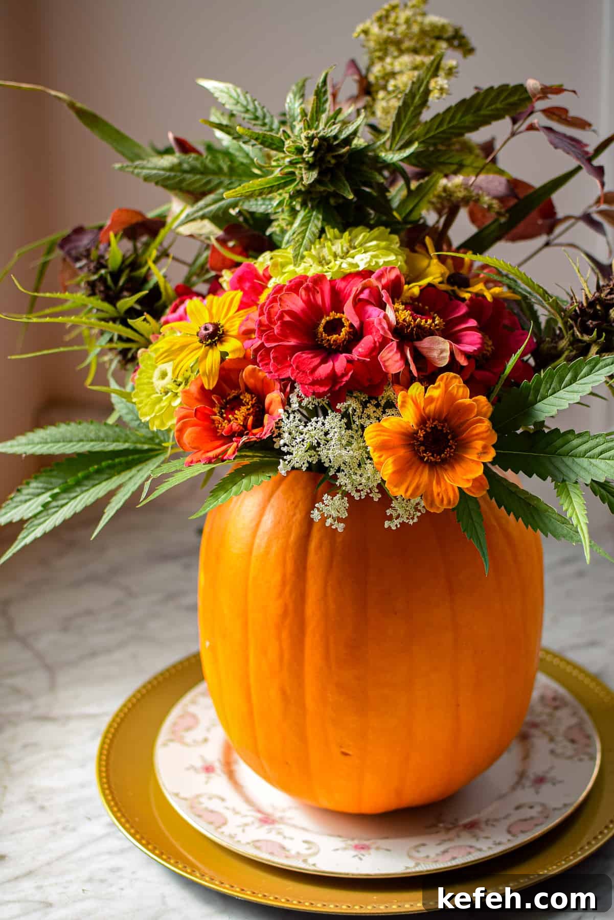 Cannabis-Inspired Fall Centerpiece Ideas for Seasonal Decor 2 A pumpkin on a plate with flowers coming out the top to create a cannabis fall centerpiece