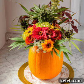 Cannabis-Inspired Fall Centerpiece Ideas for Seasonal Decor 8 A pumpkin on a plate with flowers coming out the top to create a cannabis fall centerpiece