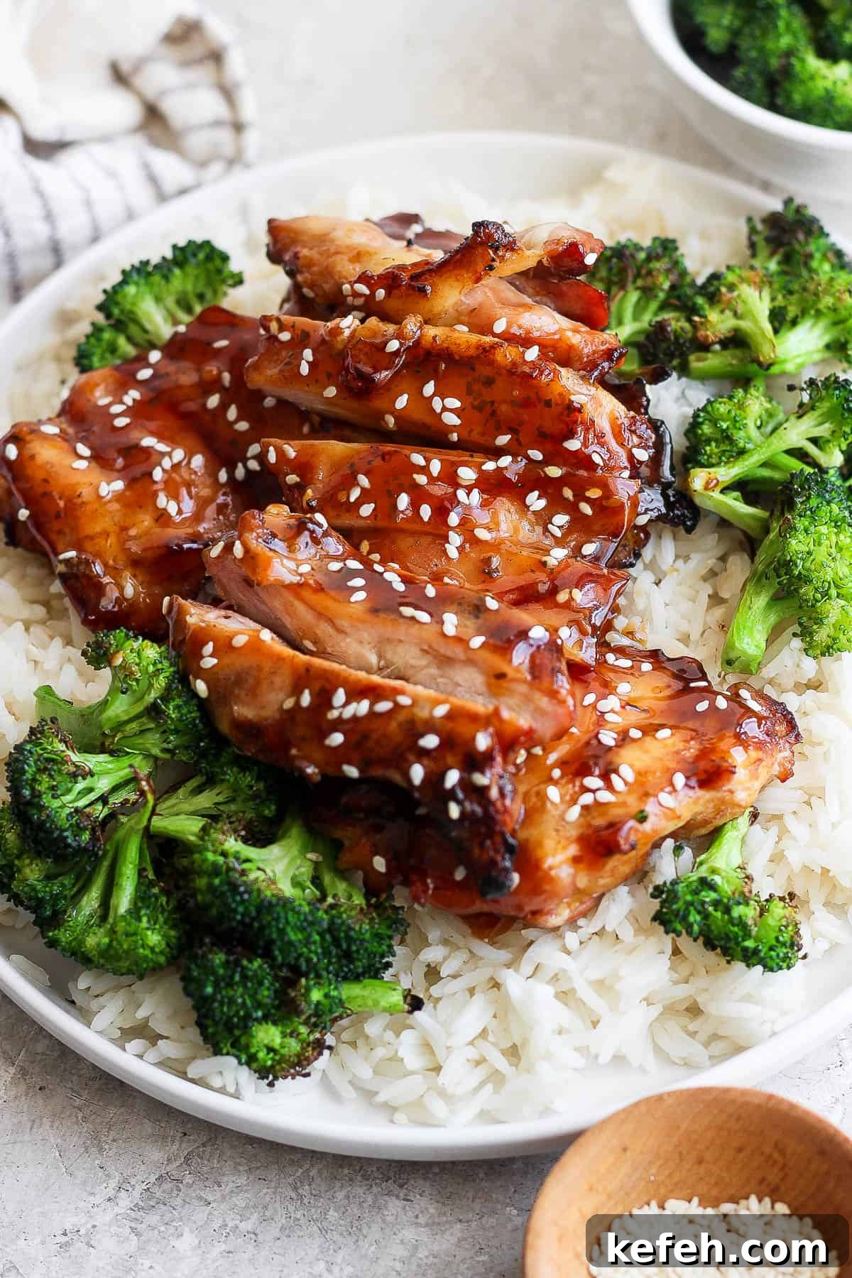 Sticky Grilled Teriyaki Chicken with Charred Scallions 5 Grilled teriyaki chicken thighs on a plate with white rice and grilled broccoli.
