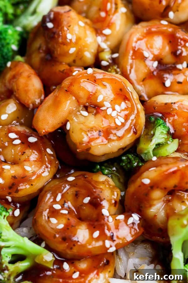 Sticky Grilled Teriyaki Chicken with Charred Scallions 9 A plate of rice covered with teriyaki shrimp and broccoli.