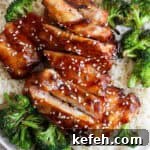 Sticky Grilled Teriyaki Chicken with Charred Scallions 10 A plate of rice topped with grilled broccoli and grilled teriyaki chicken with sesame seeds on top.