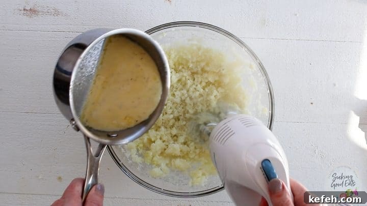 mashing the potatoes and adding the warm butter and cream