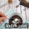 White ramekin on blue checkered linen with chocolate protein pudding and coconut cream in it and a spoon scooping some out with chocolate chips and collagen behind it