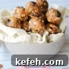 Cherry vanilla energy balls stacked in a tan bowl with a tan linen
