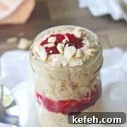 Close up of a mason jar with peanut butter and jelly overnight oats on a white cheese cloth.