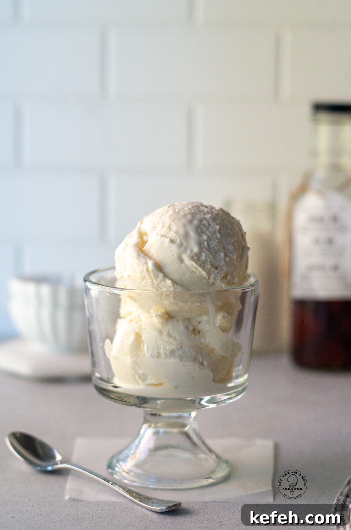 scoops of vanilla ice cream in a glass footed dish.