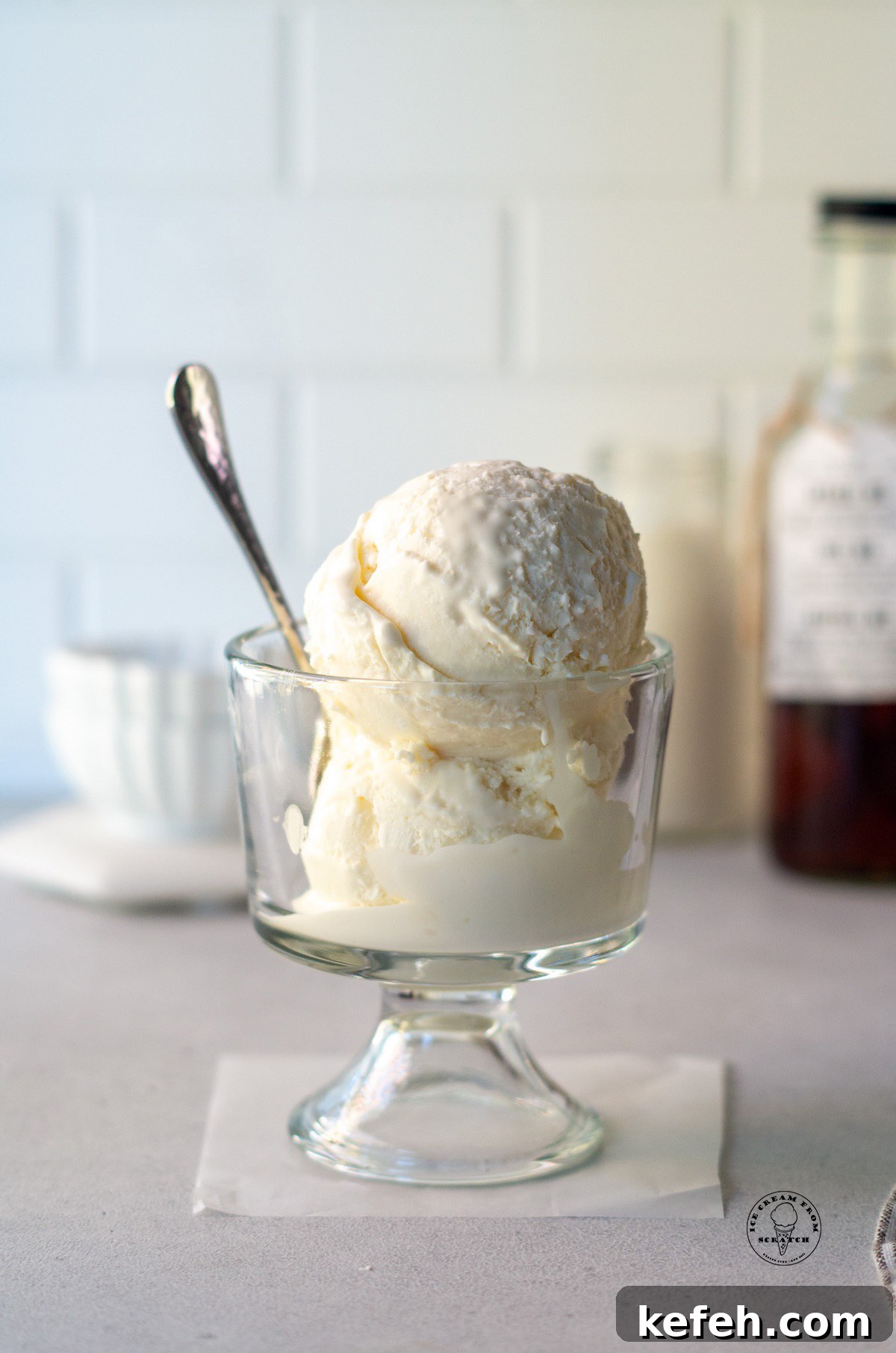 a glass dish of mexican vanilla ice cream with a spoon in it.