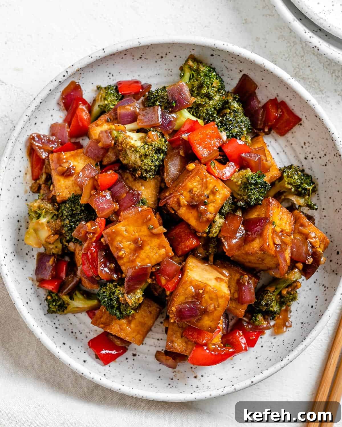 Quick Teriyaki Tofu Stir-Fry with Crisp Veggies 2 completed Vegan Teriyaki Tofu Stir Fry plated on a white bowl against a light surface