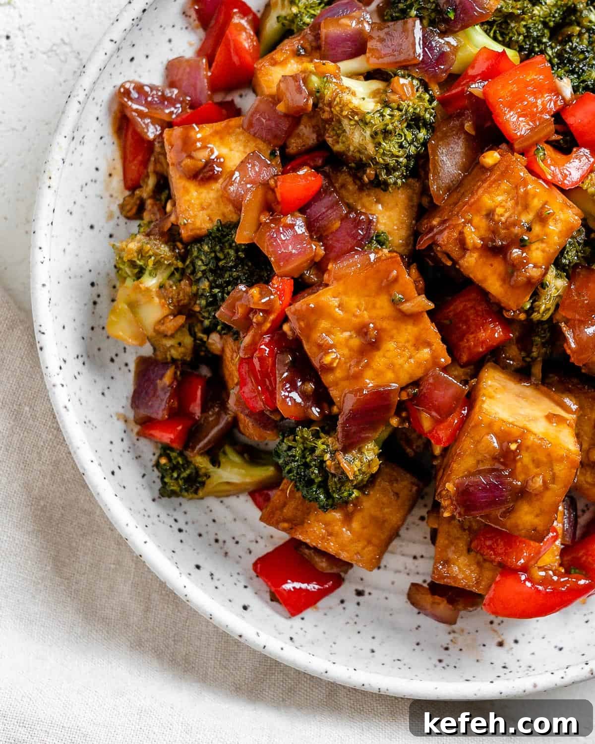 Quick Teriyaki Tofu Stir-Fry with Crisp Veggies 7 completed Vegan Teriyaki Tofu Stir Fry plated on a white bowl against a light surface