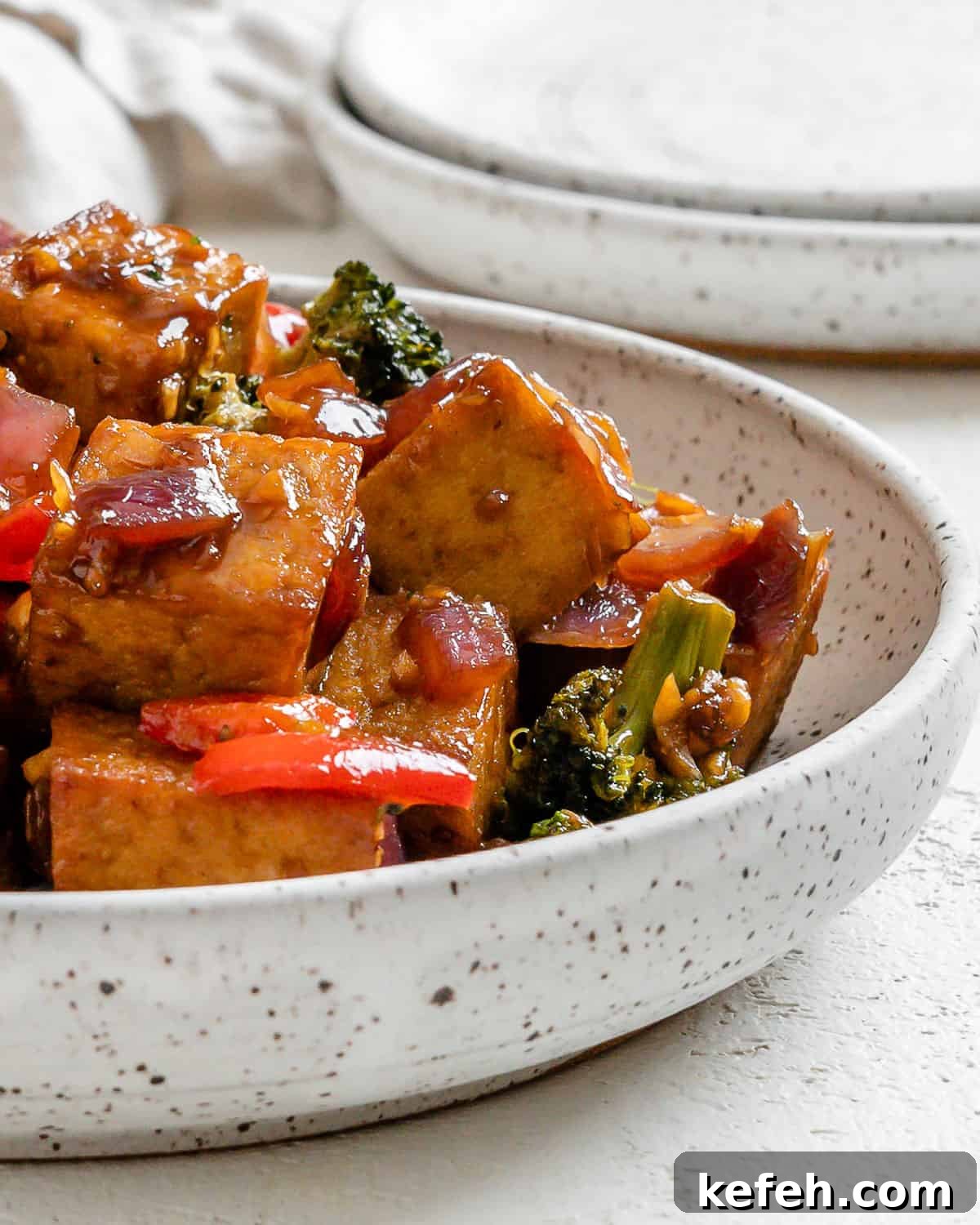 Quick Teriyaki Tofu Stir-Fry with Crisp Veggies 8 completed Vegan Teriyaki Tofu Stir Fry plated on a white bowl against a light surface
