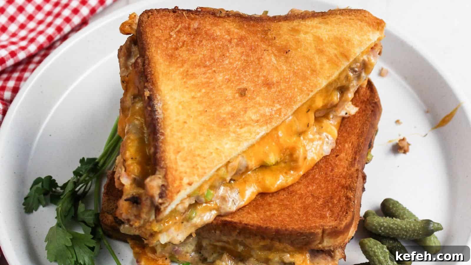30 Seafood Recipes That Turn Weeknights Into a Vacation 15 A grilled cheese tuna sandwich is cut in half on a plate.