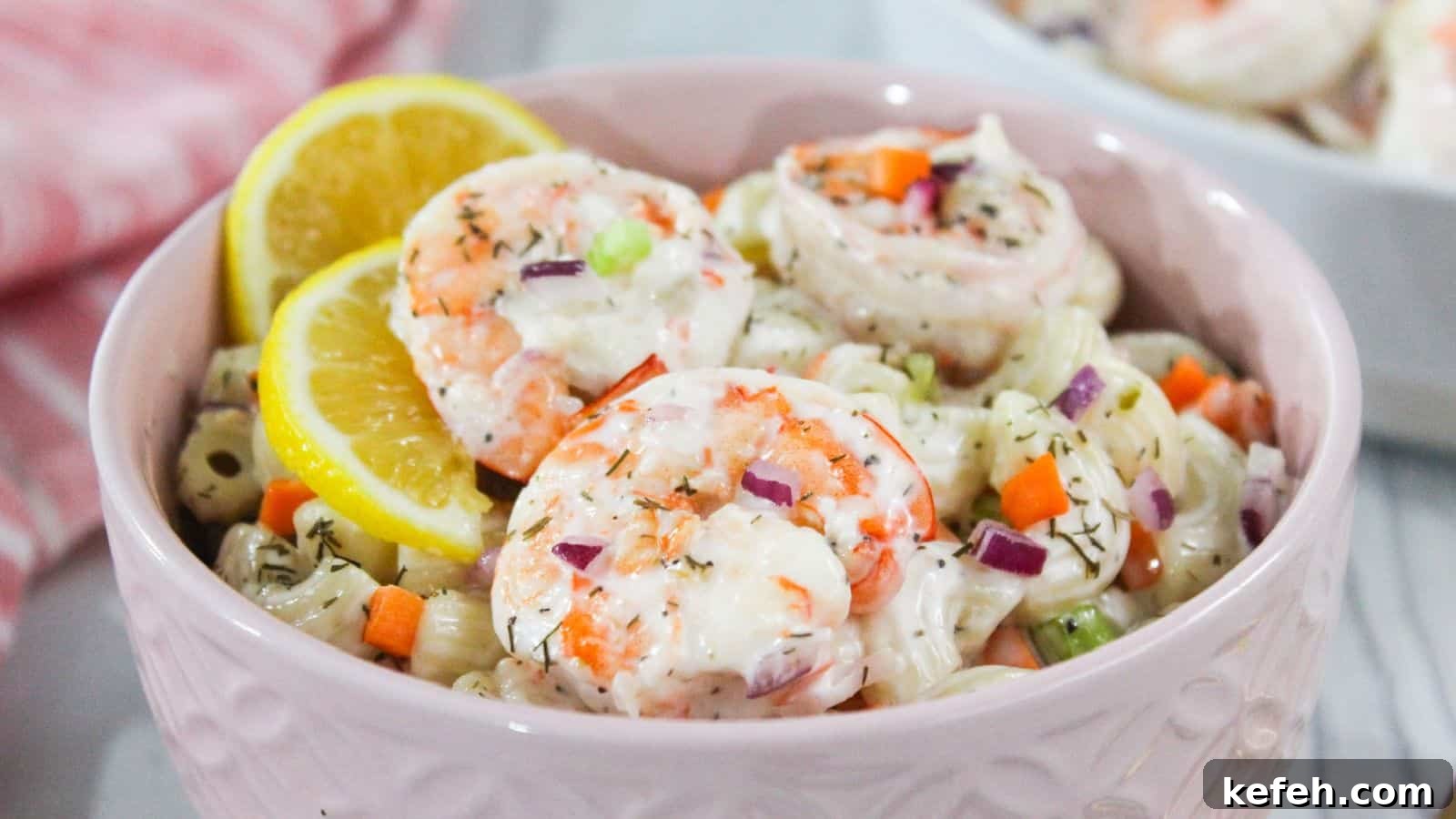 30 Seafood Recipes That Turn Weeknights Into a Vacation 22 Shrimp macaroni salad in a pink bowl with lemon wedges.