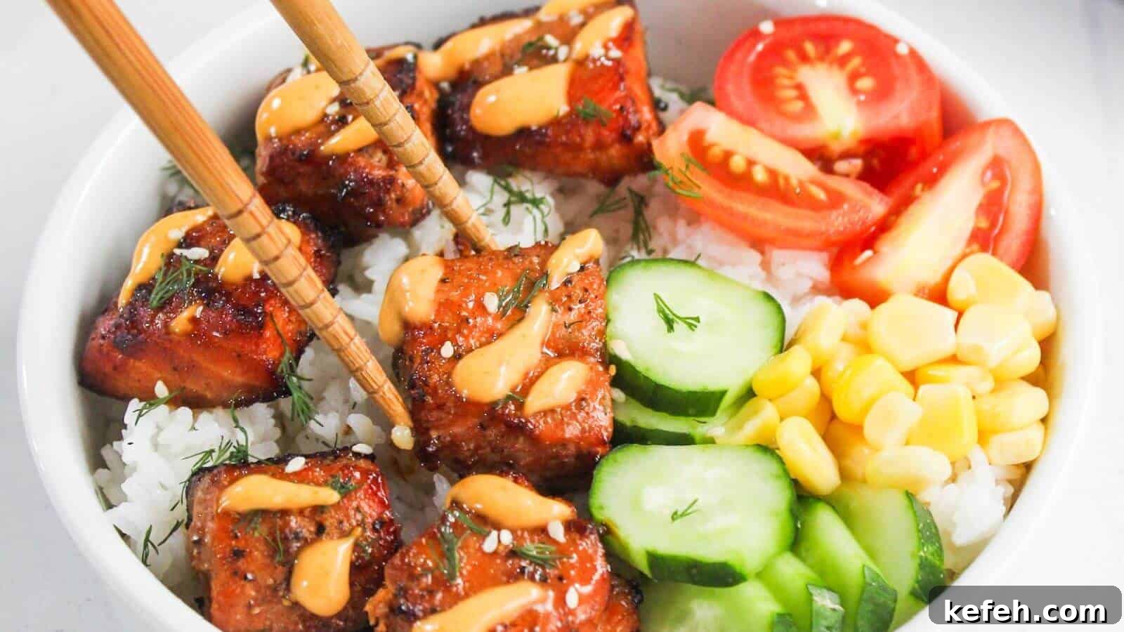 30 Seafood Recipes That Turn Weeknights Into a Vacation 5 A bowl of white rice topped with glazed salmon, sliced cucumbers, corn, tomato wedges, and a drizzle of orange sauce, with chopsticks picking up a piece of salmon.