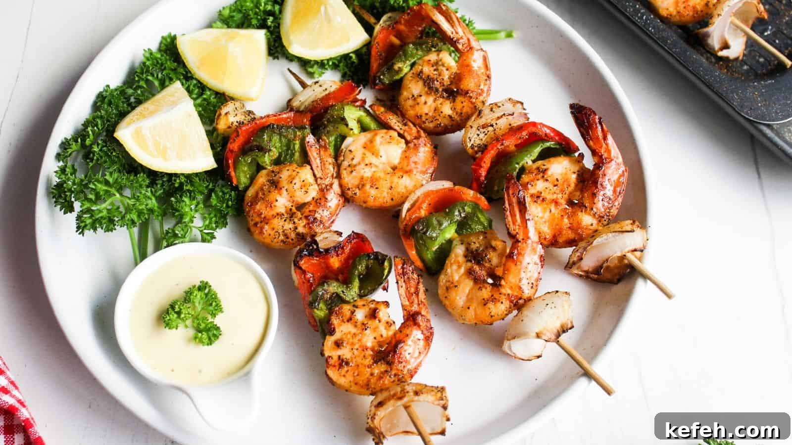 30 Seafood Recipes That Turn Weeknights Into a Vacation 10 Grilled shrimp skewers with red and green bell peppers, served with lemon wedges and a dipping sauce on a white plate.