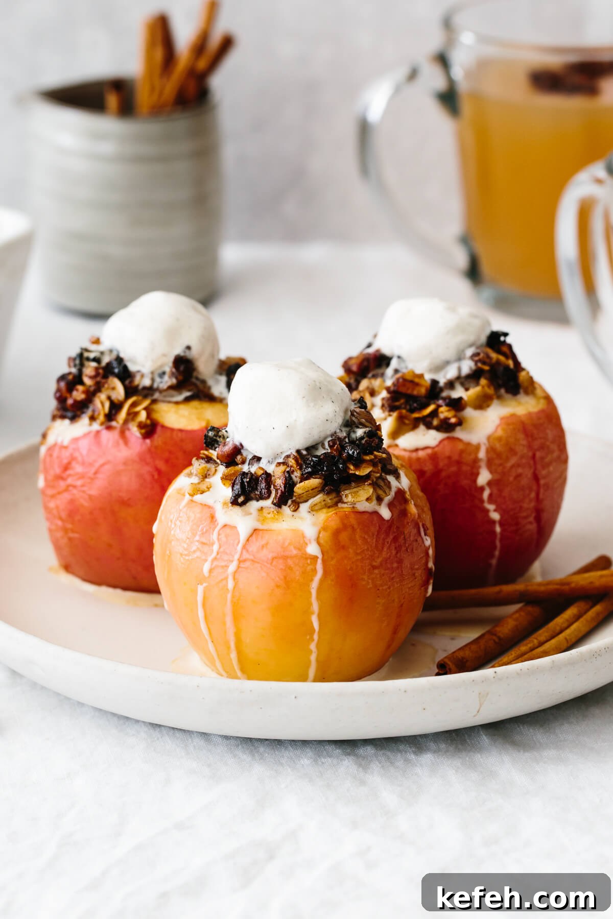 25+ Unique Thanksgiving Dessert Ideas to Impress Your Guests 2 Three baked apples on a plate with melted ice cream on top.
