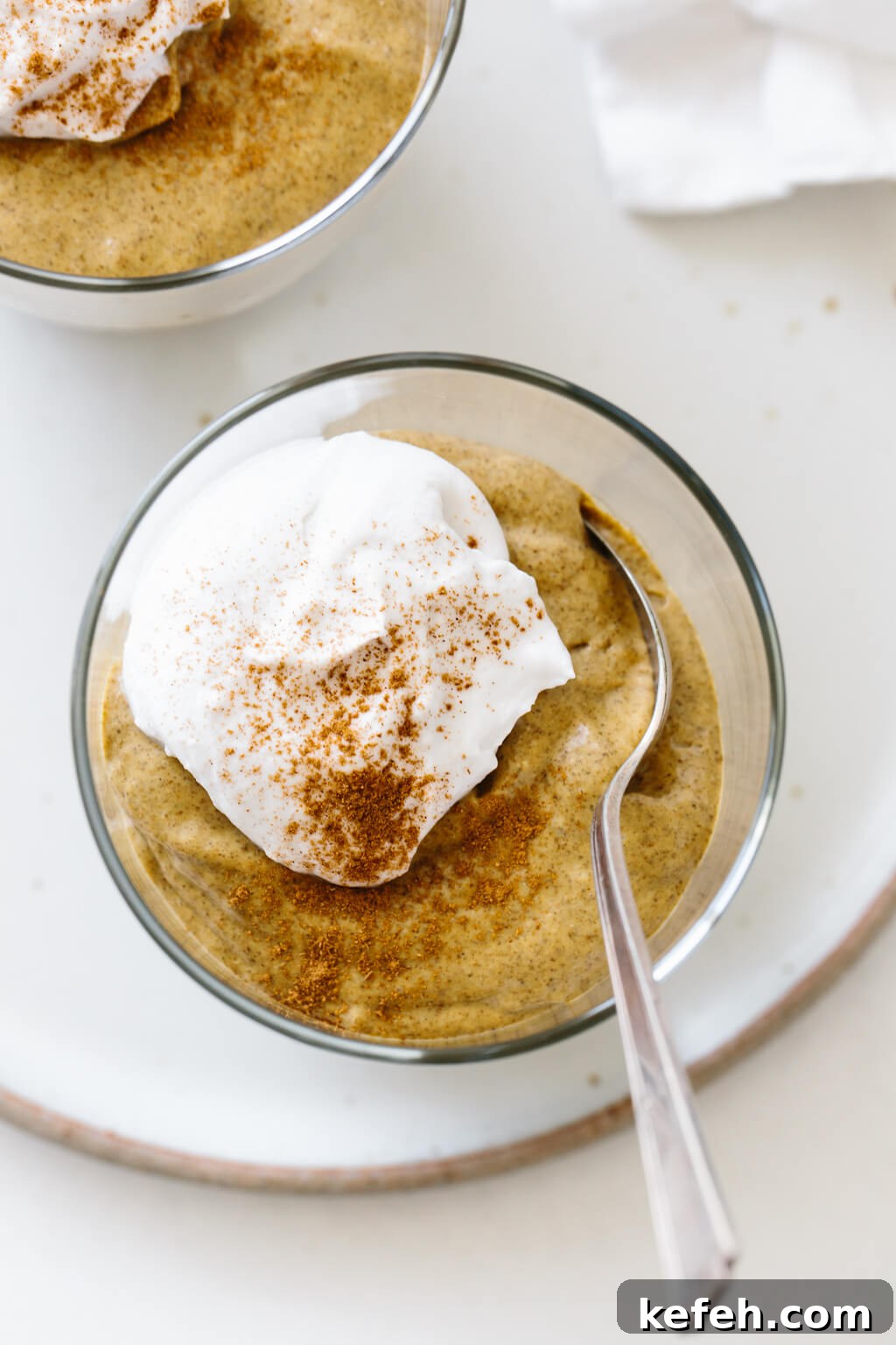 25+ Unique Thanksgiving Dessert Ideas to Impress Your Guests 3 Pumpkin chia pudding in a glass jar with a dollop of whipped cream and cinnamon.