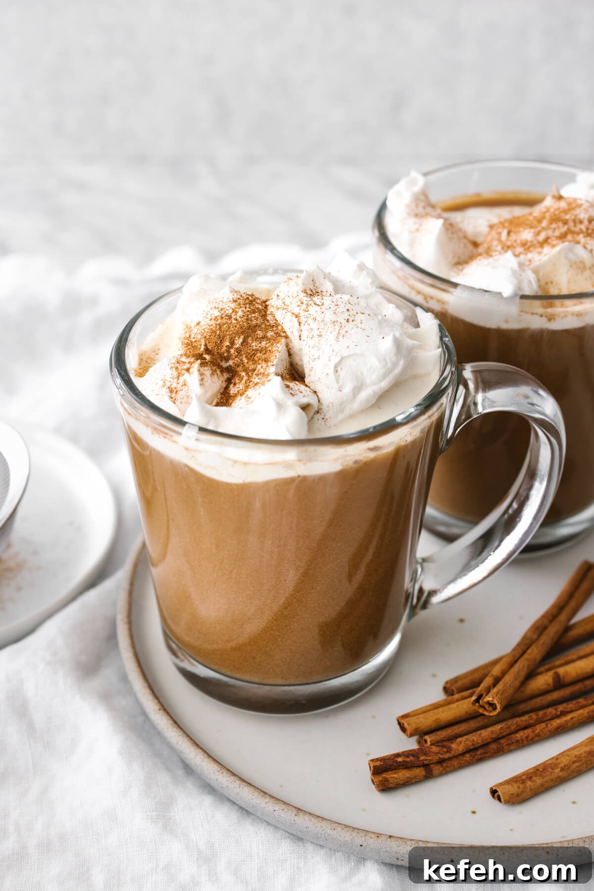 25+ Unique Thanksgiving Dessert Ideas to Impress Your Guests 4 Two cups of pumpkin spice lattes on a plate.