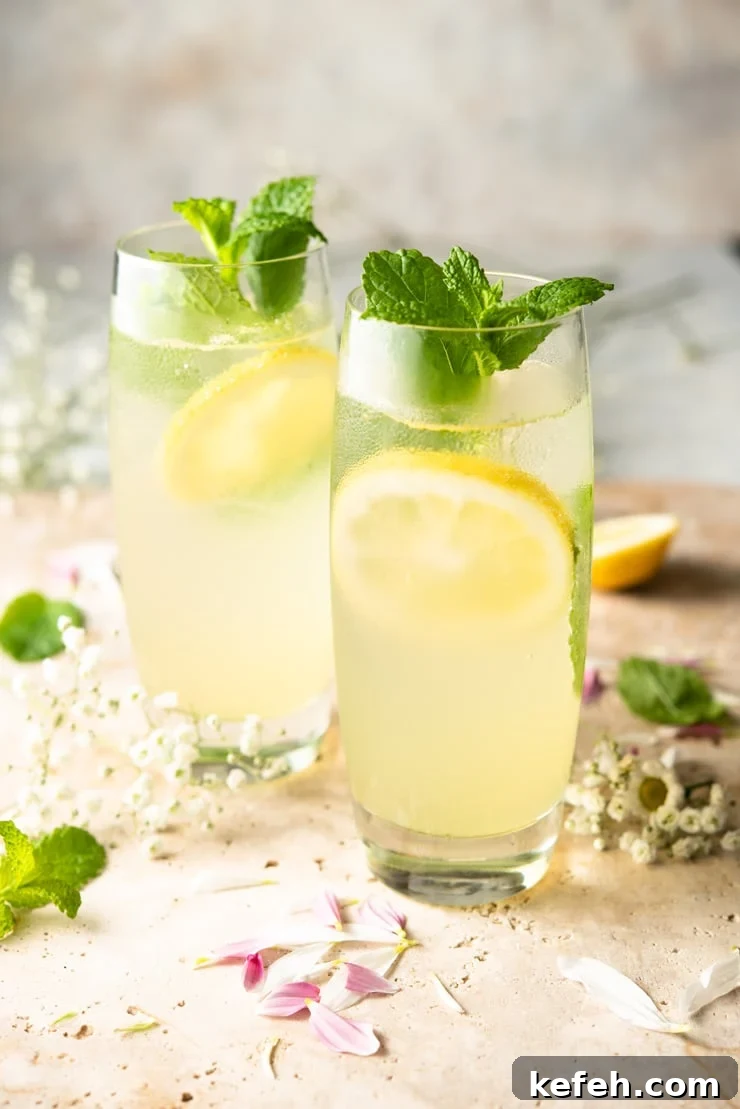 Two limoncello mojito cocktails garnished with mint and lemon