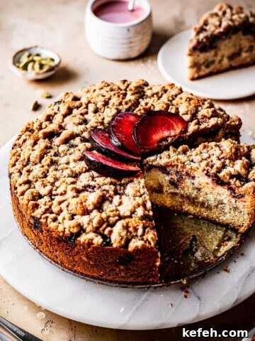 A round coffee cake with plums on top.
