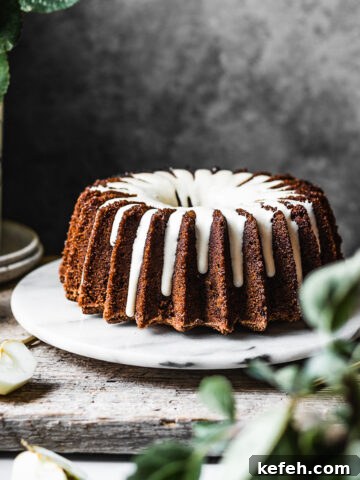 Brown bundt cake with white glaze.