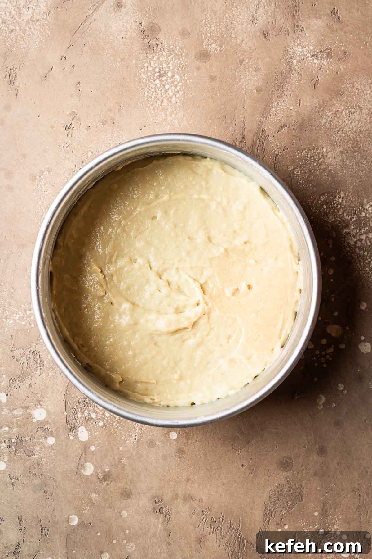 Cake batter leveled and smoothed in a cake pan.