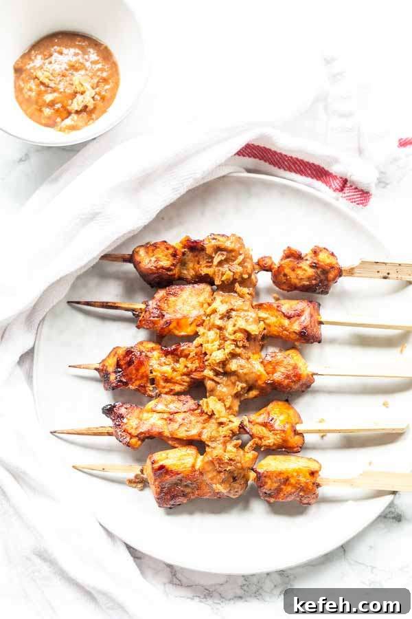 Crispy Air Fryer Chicken Satay with Peanut Dipping Sauce 5 Juicy chicken satay on a white plate served with bread. A great alternative for barbecue satay. It's easy to make in no time.