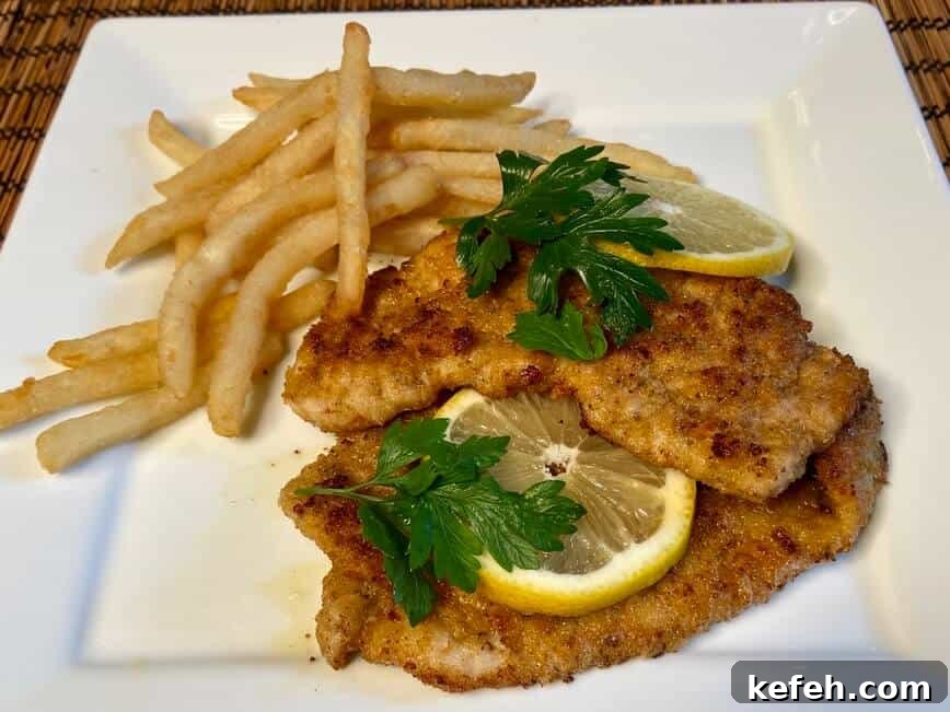 Served with slices of lemon, fresh parsley, and french fries.