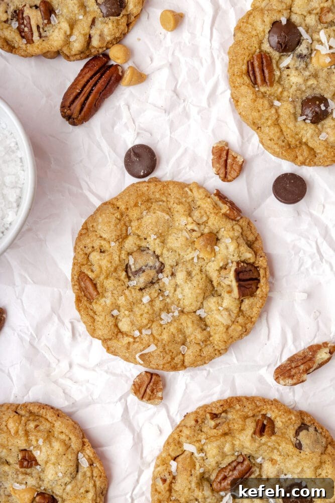 Chewy Cowboy Cookies with Oats, Chocolate & Pecans 2 picture of a chocolate chip and oatmeal cookie with butterscotch chips, pecans, coconuts, and salt on top