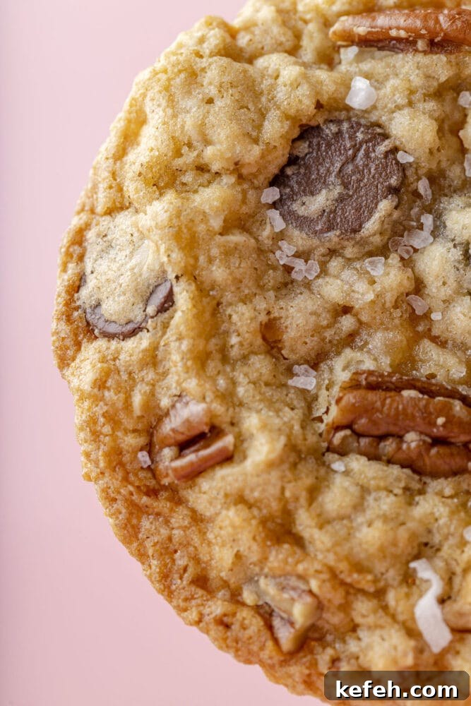 Chewy Cowboy Cookies with Oats, Chocolate & Pecans 12 picture of a chocolate chip and oatmeal cookie with butterscotch chips, pecans, coconuts, and salt on top
