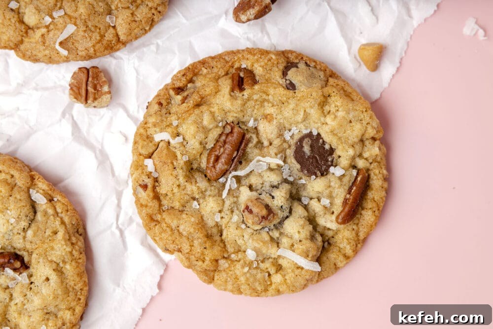 Chewy Cowboy Cookies with Oats, Chocolate & Pecans 3 picture of a chocolate chip and oatmeal cookie with butterscotch chips, pecans, coconuts, and salt on top