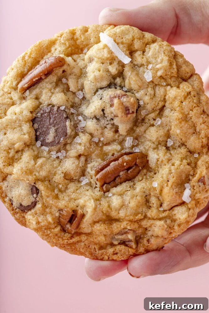 Chewy Cowboy Cookies with Oats, Chocolate & Pecans 4 picture of a chocolate chip and oatmeal cookie with butterscotch chips, pecans, coconuts, and salt on top