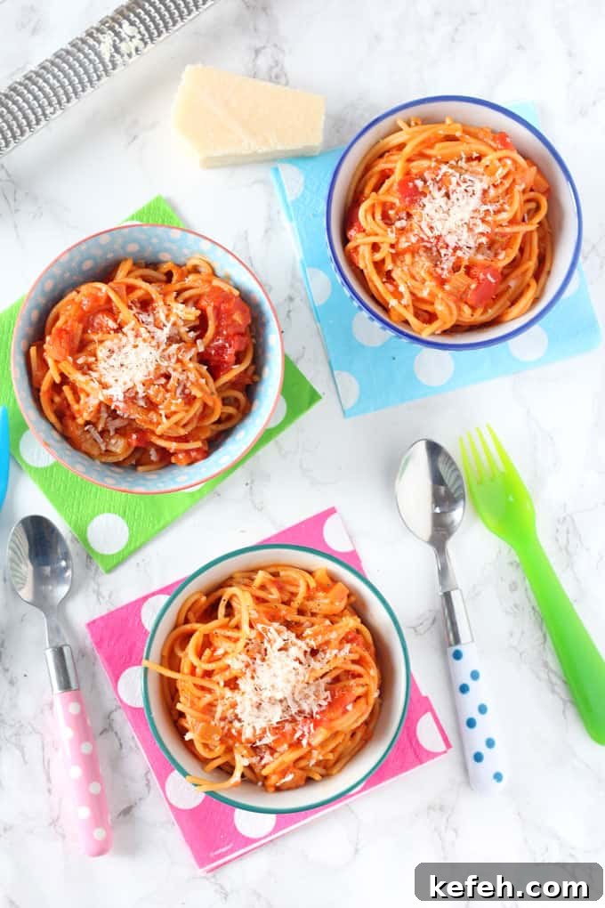 simple spaghetti & tomato sauce served in three small bowls on top of multi coloured polka dot napkins