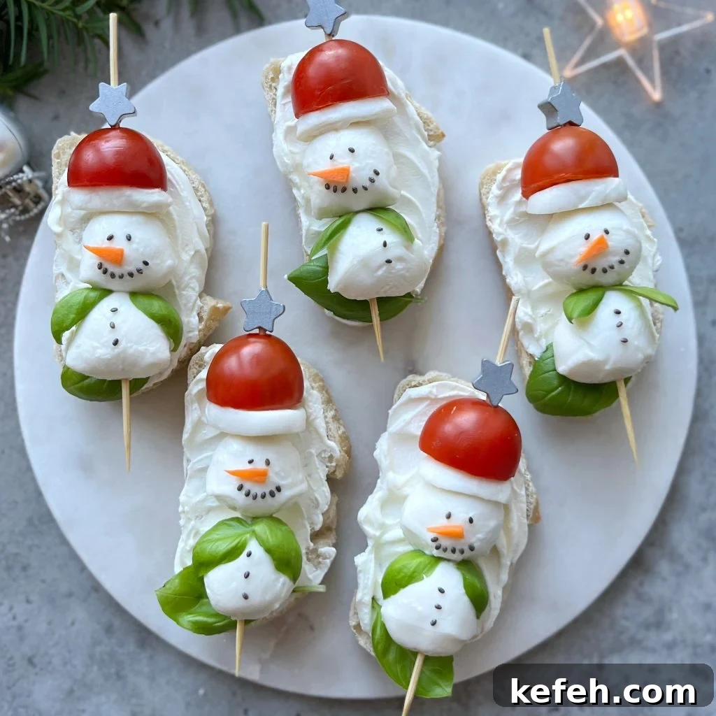 Christmas Party Appetizer Ideas to Impress Your Guests 3 Five slices of bread arranged on a marble plate, topped with cream cheese and mozzarella ball snowmen with cherry tomato hats, carrot noses, and chia seeds eyes, buttons, and mouth.