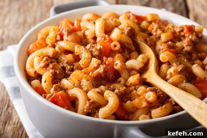 American Chop Suey (Hamburger Goulash with Elbow Macaroni), ground beef, tomatoes, tomato sauce and spices close-up in a white serving dish.
