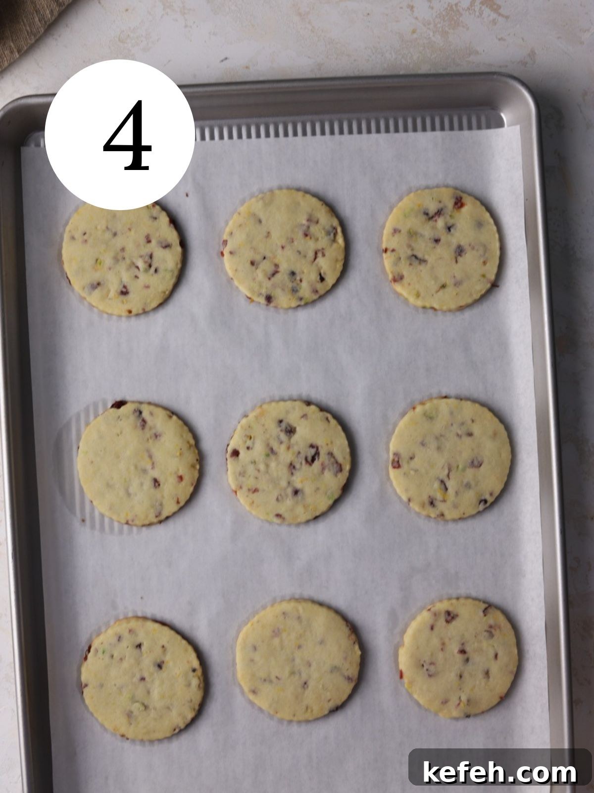 Cranberry Shortbread Cookies Recipe — Buttery Holiday Treat 7 Cranberry cookies freshly baked on a baking sheet lined with parchment.