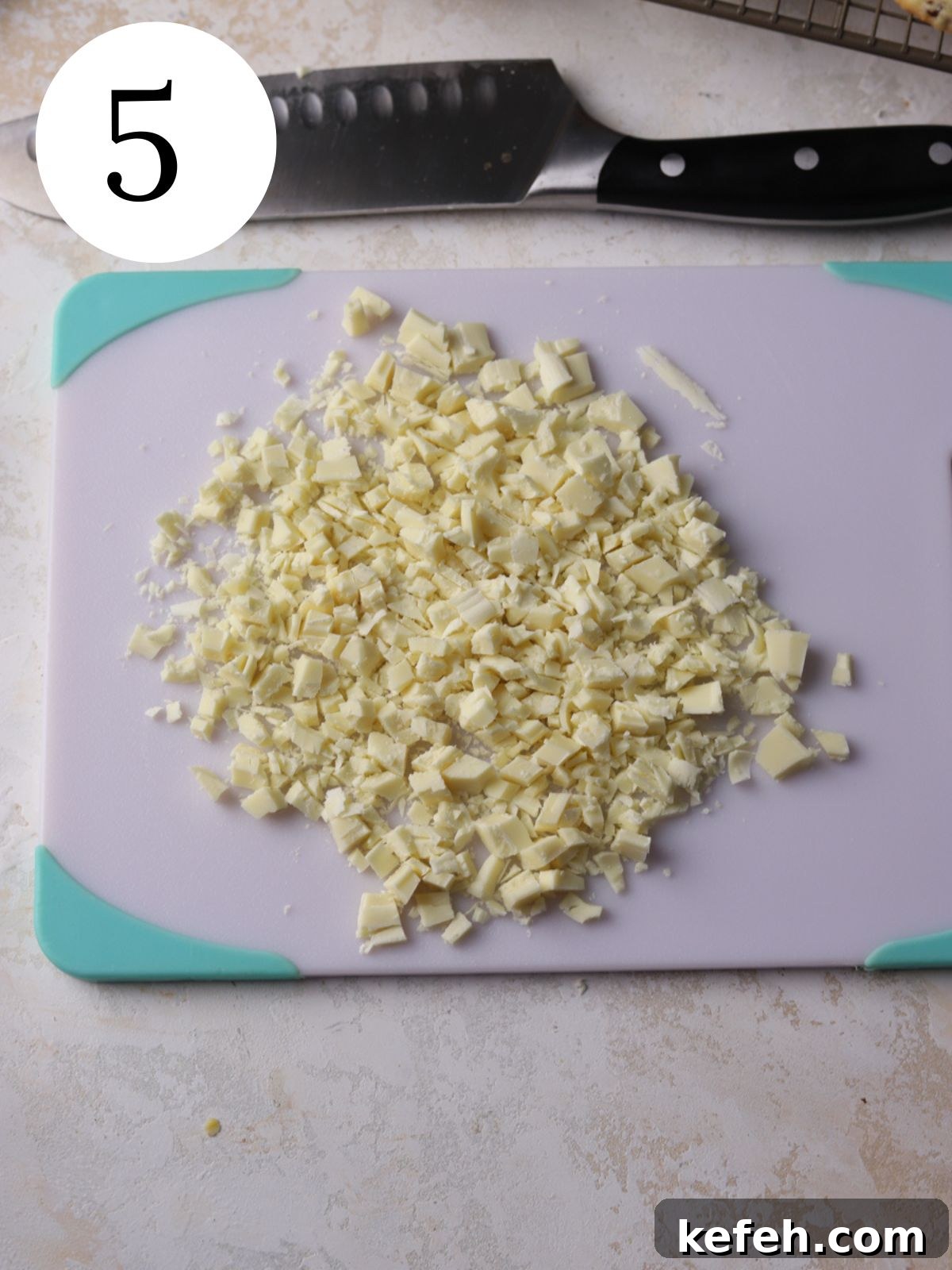 Cranberry Shortbread Cookies Recipe — Buttery Holiday Treat 8 Chopped white chocolate on a cutting board next to a knife.