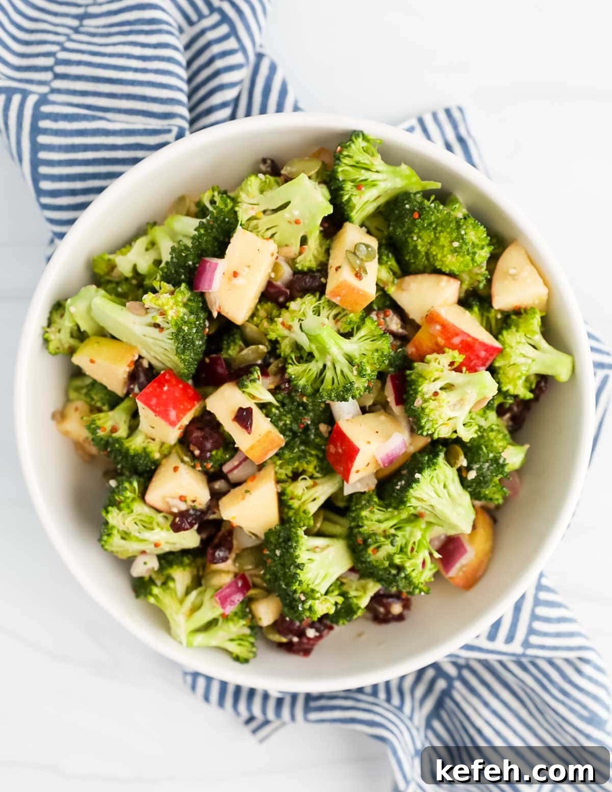 Crispy Broccoli Crunch Salad with Bacon and Sunflower Seeds 7 A white bowl filled with broccoli salad.