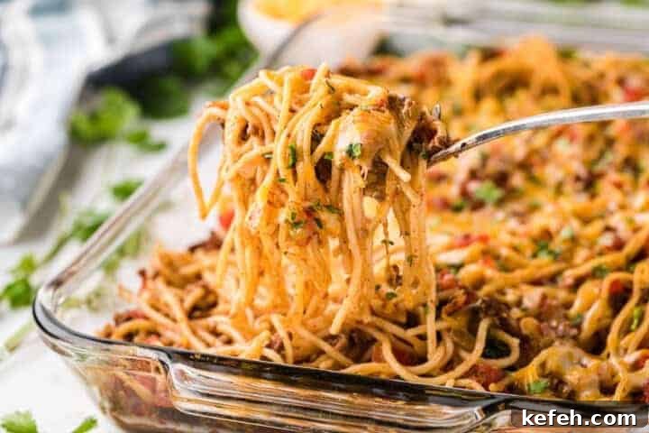 30 Ground Beef Dinner Recipes for Quick Family Meals 10 Taco Spaghetti being served of a glass baking dish.