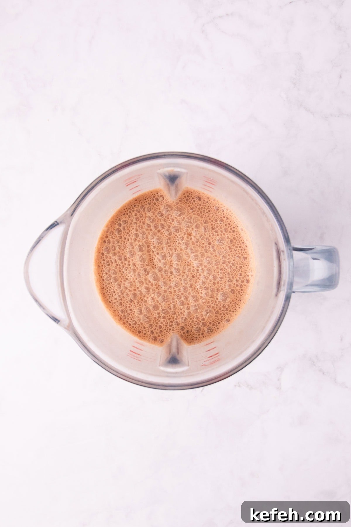 Creamy Mocha Milkshake Recipe for Coffee Lovers 6 Overhead view of the blended shake in a clear blender jug.