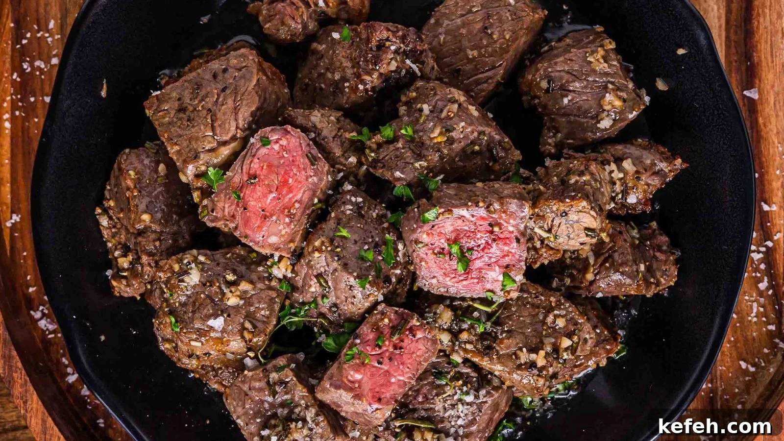 17 Budget-Friendly Steak Recipes to Feed a Crowd Without Breaking the Bank 5 Air fryer steak bites coated in garlic butter served hot with crispy browned edges.