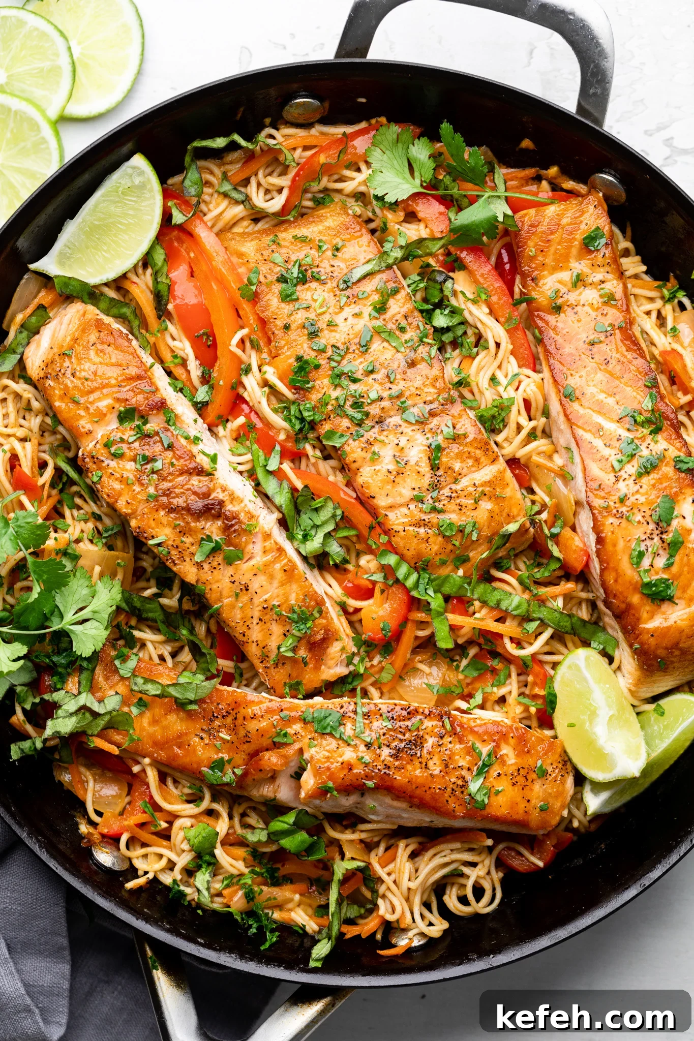 gluten free ramen noodles with thai curry salmon in a black skillet