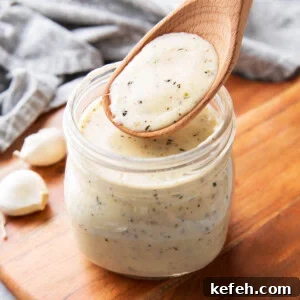 jar filled with creamy, rich garlic parmesan sauce thickened with cheese and herbs