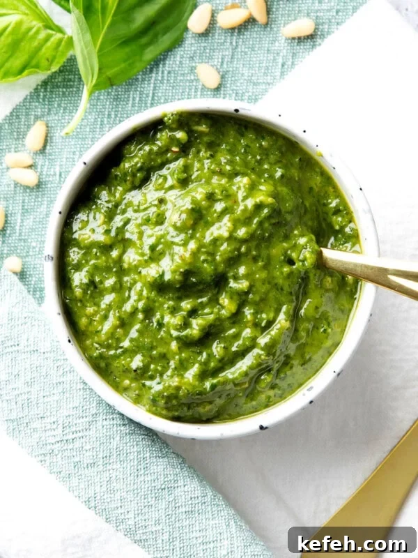 Homemade basil pesto sauce is packed with fresh basil, pine nuts, and parmesan, served in a bowl