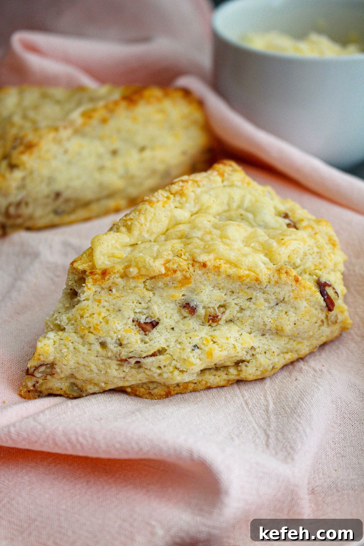two white cheddar scones on a kitchen towel.