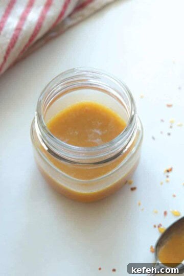 jar full of spicy honey mustard with spoon on the side